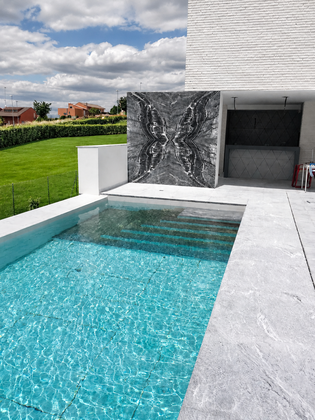 Piscina com parede de book-match em mármore cinzento